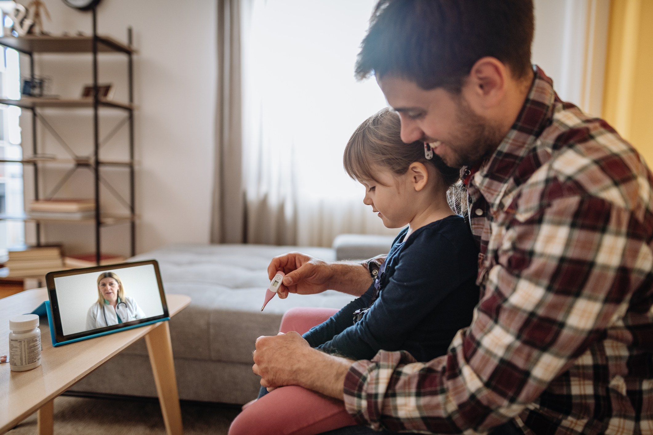 father-and-son-having-virtual-visit-with-doctor-on-tablet-computer_istock-1311113570.jpg