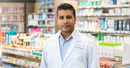 male pharmacist standing in pharmacy