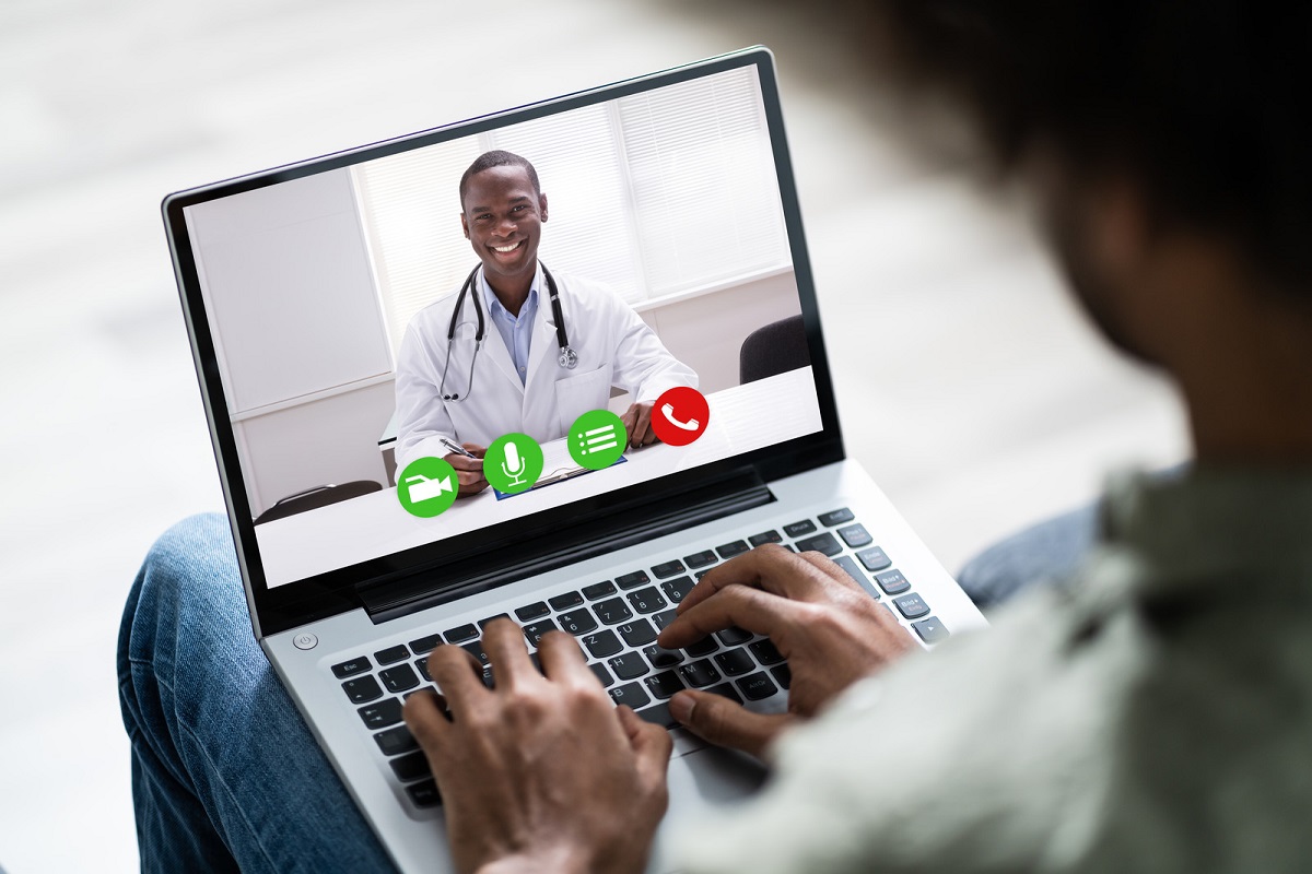Man videoconferencing with doctor on laptop 