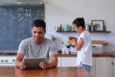 couple in kitchen, male looks at tablet