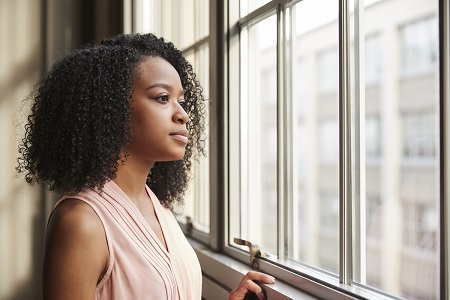 young black woman looking out a window